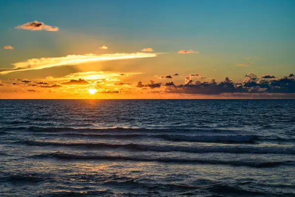 Deniz sahili arka planında gün batımı. Yaz denizi olan doğa duvar kâğıdı. Su deniz dokusu. Tropikal denizde sakin bir gün doğumu