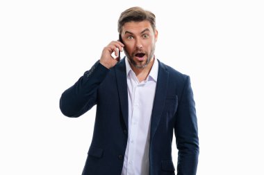 Takım elbiseli yakışıklı bir iş adamının portresi. Akıllı telefon kullanıyor, sohbet ediyor, sosyal medyada mesaj yazıyor. Telefondaki iş adamı araması stüdyo geçmişinden izole edilmiş. Blog yazarı telefonda konuşuyor