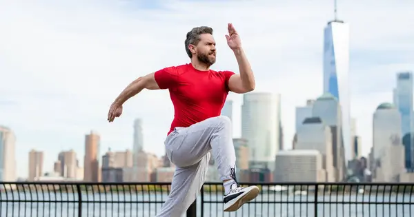 ニューヨークで開催されるスポーツ衣装の男ランナー 健全な走り マンハッタンのダウンタウンの近くを走る成熟したジョギング マッサージアスリートスポーツマンが市内を走る スポーツウェアを走る ハンサムな男ランニングワークアウト屋外 — ストック写真