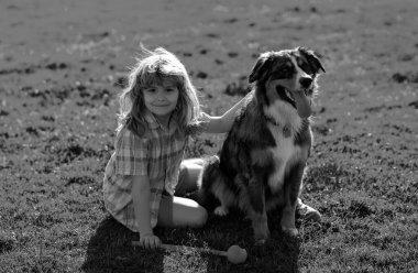 Parkta evcil köpeği olan küçük bir çocuk. Yavru köpeği olan sevimli bir çocuk, açık hava yazı. Mutlu bir çocukluk. Komik köpek.