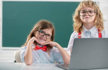 Okul arkadaşları birlikte öğreniyor. Okul üniformalı arkadaş canlısı sınıf arkadaşları dersteler. Okuldaki erkek ve kız çocuklar. Okul çocukları, arkadaşlık, okul arkadaşları. Sınıf arkadaşı çift, ilkokul öğrencisi.