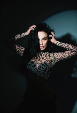 Gölgedeki kadın. Yüzünde gölgeler olan kadın model. Işıklı dramatik siyah stüdyoda baştan çıkarıcı ve şehvetli görünüyor. Gece kulübü seksi kız.