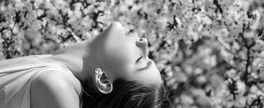 Bahar kadını yüz konsepti. Yeşil bahar bahçesi arka planında güzel bir kız. Sancak bahar tasarımı, web sitesi başlığı reklamı. Bahar çiçeği arkaplanı