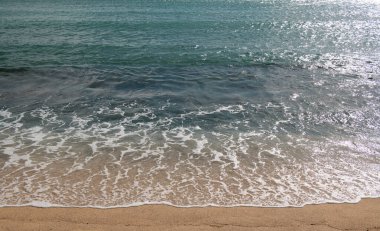 Plaj geçmişi. Kumlu sahilde sakin, güzel bir okyanus dalgası. Tropikal deniz manzarası