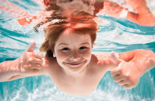 Funny excited kids face under water. Child in pool in summer day. Child swim under water in sea. Kid swimming in pool underwater. Happy boy swims in sea underwater. Children in water