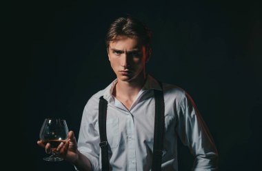 Viski, konyak, konyak içen bir adam. Degukasyon ve tatma. Bir bardak konyaklı adam. Bir bardak viskisi olan erkek model.