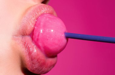 Seksi oral seks sembolü. Seksi ağzı olan, chupa yiyen bir kız. Kadın dudakları lolipop emiyor. Ağzında lolipop tutan kadın, kapat. Kırmızı dudaklar, şehvetli ve seks dükkanı konsepti