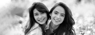 Açık havada kadın kız arkadaşlarla bahar pankartı. Parkta kameraya bakan iki komik arkadaşın portresi. Millet, boş zaman ve eğlence kavramı