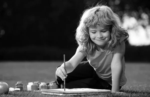 子供たちは創造的な休暇を描きます 公園の屋外で塗料の色とブラシで子供の男の子の絵 — ストック写真
