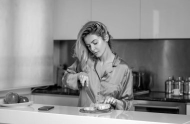 Evdeki mutfakta peynir ve sosis kesen güzel bir kadın. Ev hanımı sabahları mutfakta yemek pişiriyor.