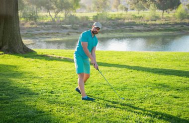 Golfer with golf club taking a shot