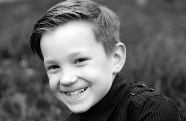 Çocuk portresi. Gülümseyen tatlı bahar çocuğunun yakın yüzü. Çocuk duyguları konsepti. Dışarıdaki gülen çocuğun portresi.