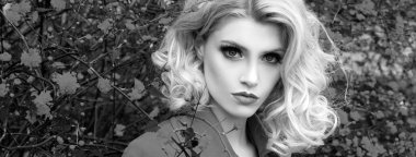 Bahar kadını pankarta karşı. Sarışın, yüksek moda mankeni bir kız. Canlı Makyaj. Çiçek tarlası olan güzel bir model kadın. Bahar çiçeği arkaplanı