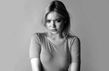 Mavi gözlü kızgın genç bir kadının stüdyo portresi. Üzgün kız suratı. Gençlik ve cilt bakımı kavramı