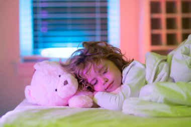 Sessiz bir uyku. Çocuk biraz kestir. Yatakta oyuncak ayıyla uyuyan bir çocuk. Yatak odasında rahat bir yatak. Yumuşak yastık, rahat, rahat yatak konsepti. Sağlıklı çocuklar uyuyor.