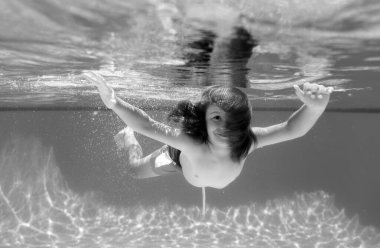 Deniz ve deniz eğlencesi. Sualtı çocuğu havuzda yüzer, sağlıklı çocuk yüzer ve suyun altında eğlenir.