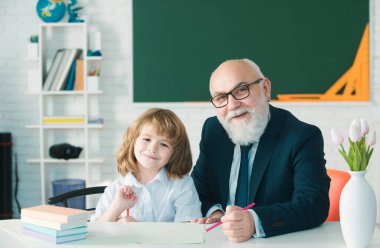 Öğrenmeme yardım et. Öğrenci çocuk dersi. Öğretmenim. Eğitim konsepti. Eski öğretmen ve okul çocuğu sınıfta.