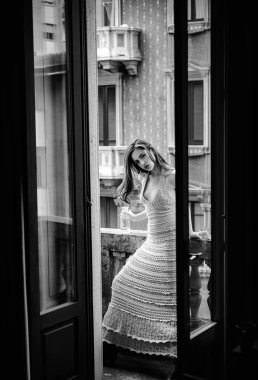 Balkonda moda düşkünü bir kadın. Dışarıdaki kız. Şehir portresi