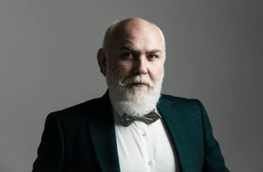 Son sınıf öğrencisi. 60 yaşında bir adam. Gri üzerine izole edilmiş kameraya bakan tatmin olmuş yetişkin iş adamı