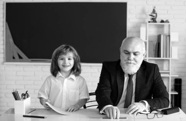 Okuldaki mutlu çocuk. Öğretmenin öğrenmesine yardım et. Eğitim, öğretmenlik, ilkokul