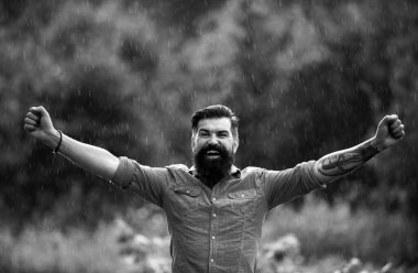 Fırtınalı yağmurlu hava konsepti. Su geçirmez giysi. Yağmur altındaki mutlu adam. Sonbahar havası