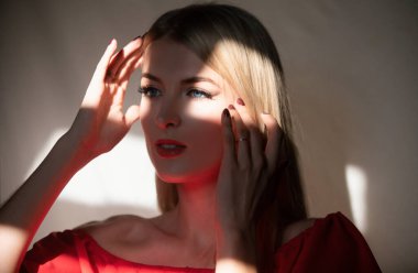 Siyah arka planda poz veren zarif genç bir kadın. Işık ve gölge. Güzel bir kadının portresi.