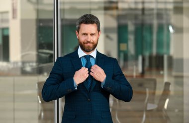 İş merkezinin yakınında bir ofis çalışanı. İş adamı iş merkezinin yakınındaki caddede duruyor.