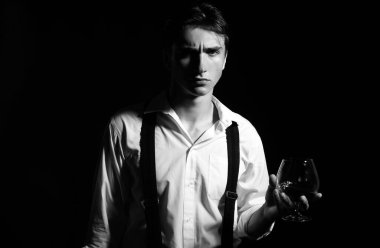 Bir bardak viskisi olan adam. Pahalı bir içki. Erkek brendi ya da konyak içiyor. Degukasyon, tatma