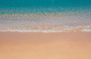 Kumlu sahilde mavi okyanus dalgası. Yaz mevsiminde gün batımında plaj. Plaj manzarası. Tropik deniz manzarası, sakinlik, dinlendirici güneş ışığı