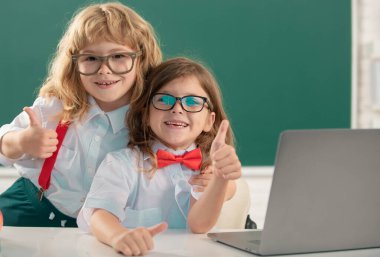 Okula dönelim. İlkokulda okuyan iki mutlu okul çocuğunun portresi, kucaklaşan ve neşeyle gülümseyen okul çocukları.