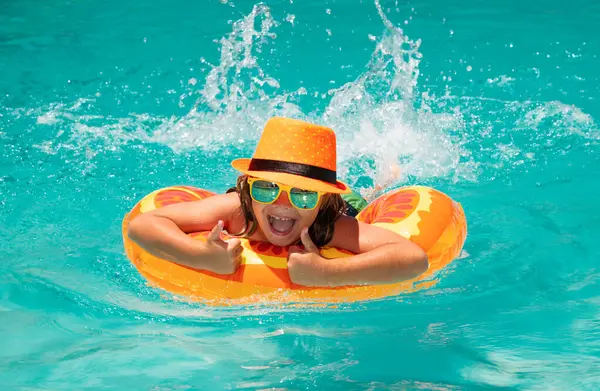 Çocuk havuzda yüzüyor. Çocukla yaz tatilinde su sporu etkinliği