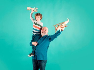 Oyuncak uçağı ve tahta kamyonu olan çocuk ve büyükbaba. Erkek nesli büyükbaba ve torun