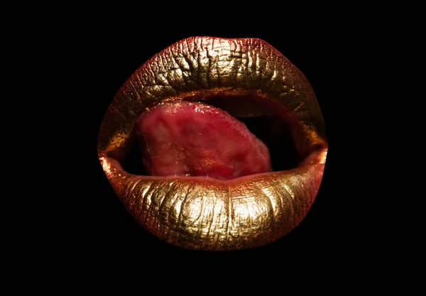 Gold lips. Gold Paint on mouth. Golden lips on woman mouth. Sensual sexy lip. Isolated woman golden mouth with tongue out