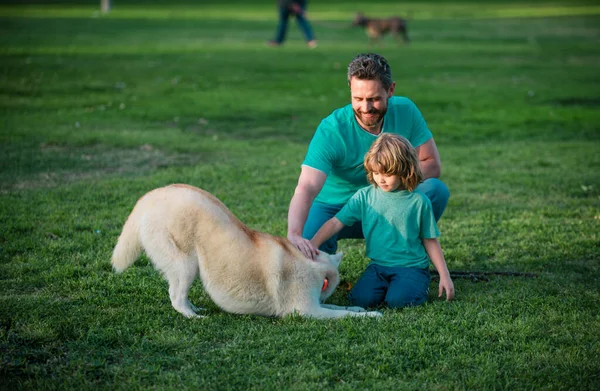 Father and son with dog on nature. Concept of friendly family with dog. Child with pet friend