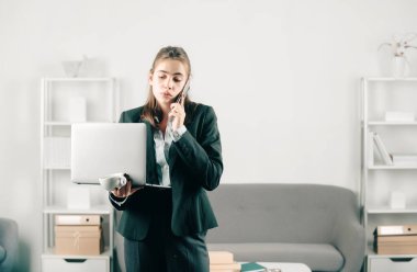 Ciddi bir iş kadını. Ofis müdürü. Ofis masasında telefonu var. Ofiste çalışan iş kadını girişimci, işyerinde çalışan profesyonel bir çalışan. Genç güzel sekreter kız.