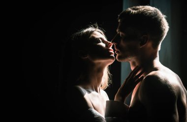 Tutkulu bir öpücük. Birbirine aşık güzel bir çiftin portresi. Genç şehvetli kız arkadaşı, erkek arkadaşından tutkulu bir öpücük aldığı için mutlu. Yakışıklı adam kadınını kucaklıyor ve öpüyor.