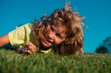 Çocuk güneşli bir yaz gününde dışarıda dinleniyor.
