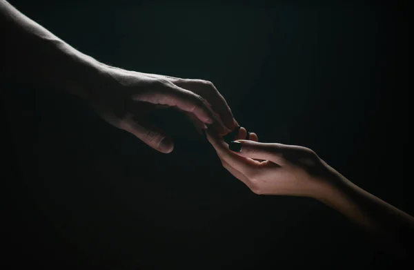 Two hands. Helping hand to a friend. Rescue or helping gesture of hands. Concept of salvation. Hands of two people at the time of rescue, help. Isolated on black background. Tenderness, tendet touch