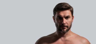 Yüzünde krema olan çekici bir adamın yakın plan portresi. Güzel adam beyaz arka planda yakın plan portresi. Çıplak omuzlar, cilt bakımı, sağlık, cilt için kozmetik. Başlık için pankart, kopyalama alanı