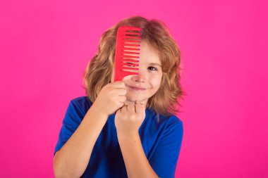 Çocuk duştan sonra saçlarını tarıyor. Taraklı ve sorunlu saçlı bir çocuk. Çocuk şampuanı. Saç kremi olmadan taranmaz.