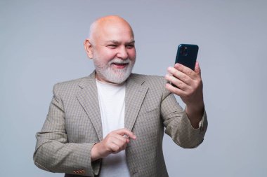 Akıllı telefon kullanan kıdemli bir adam, gülen surat. Olgun adam cep telefonuyla konuşuyor.