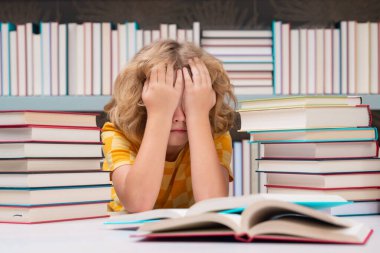 Eğitim Konsepti. Öğrenci çocuk kütüphanede kitap okuyor. Çocuk gelişimi, okumayı öğrenmek. Öğrenci kütüphanede kitap okuyor. Ödev yapan okul çocuğu, sıkı çalış.