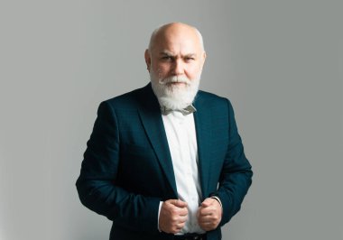 Gri arka planda izole edilmiş gri saçlı yaşlı adamın yakın plan portresi. İhtiyar. Belden yukarı portre