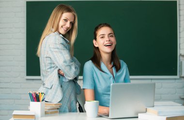 Öğrenci kızlar üniversitede birbirleriyle konuşuyorlar. Arkadaşlarla sınava hazırlanma ve öğrenme