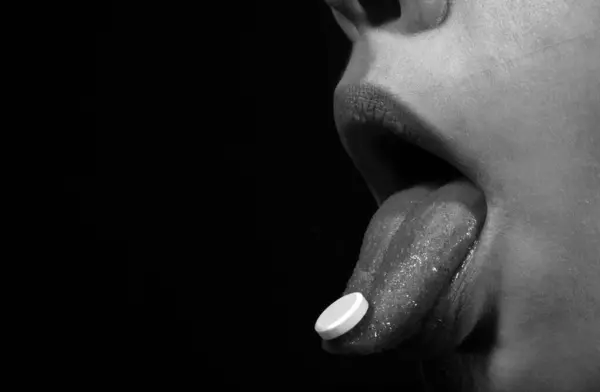 女性舌头上的药丸特写 舌头把药丸放在张开的嘴里 关闭生病妇女服用避孕药以减轻疼痛概念 每日补充剂或抗生素抗抑郁剂的口腔 — 图库照片