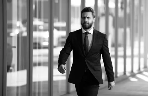 Businessman walking outside business centre. Portrait of a confident young business man walking in the city