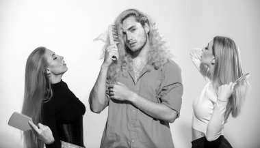 Uzun, parlak, ipek saçlı güzel bir çift ve sarı kıvırcık saçlı bir adam taraklı saçlarını tarıyor. Saç tarayan gençlerin toplu portresi