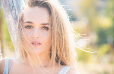 Dışarıda güneş ışığının tadını çıkaran genç bir kadın. Temiz tenli genç bir kadın. Dışarıdaki zarif genç bayanın şehvetli portresi. Güzel, şık bir kız.