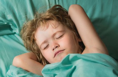 Çocuklar yatakta uyur. Küçük çocuk uykuya daldı. Sağlıklı ve huzurlu bir uyku çek.