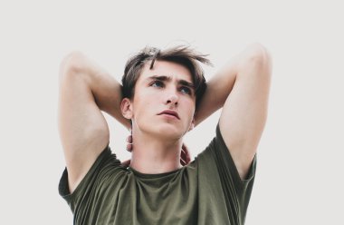 Stüdyo fotoğrafında genç adam yukarı bakıyor. Kendine güveni olan yakışıklı adam.